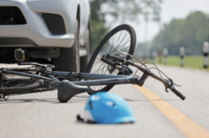 Bicycle on the road after being hit by a car, with a helmet nearby