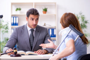 Injured woman with a neck brace and crutches consulting a lawyer in an office