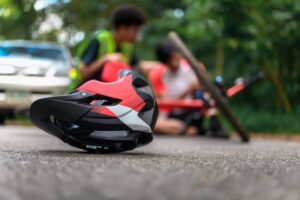 Close-up of a bicycle helmet on the street after a mountain bike accident, as the injured cyclist awaits first aid.