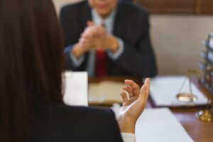 Legislation and justice concept: Young female lawyer discussing contract law with a senior attorney in a professional setting.