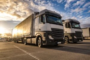 Trucks in a row with containers in the parking lot. Logistic and Transport concept