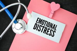 A stethoscope and a white paper with the words "Emotional Distress." Mental suffering as an emotional response to an experience resulting from its impact.