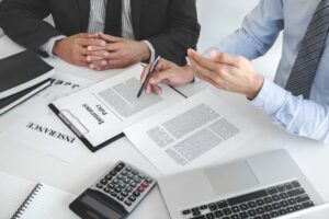 Insurance agent discussing policy details with a customer in an office.